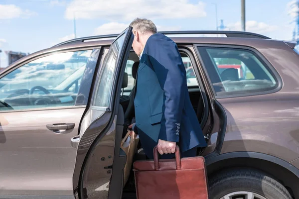 Şehirde arabanın yanında duran adam. 