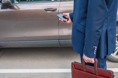 Müşteri kapıyı açmak için cep telefonunu tutuyor. Araba paylaşım servisi veya kiralama kavramı. 