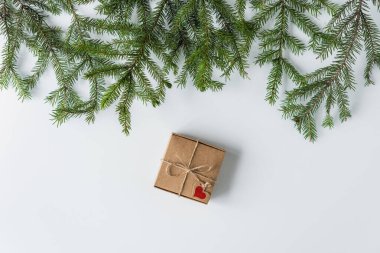 Beyaz ahşap masadaki bir kutu kraft kağıdının içinde hediye paketi. Noel ağacı, ladin dalları. konsept. Yeni yıl. konsept. Düz yatış, üst görünüm