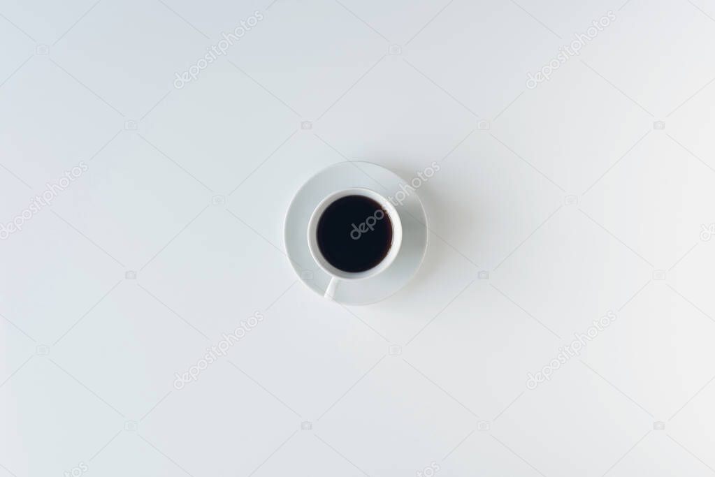 cup with black coffee on the white table. flat lay, top view. coffee art