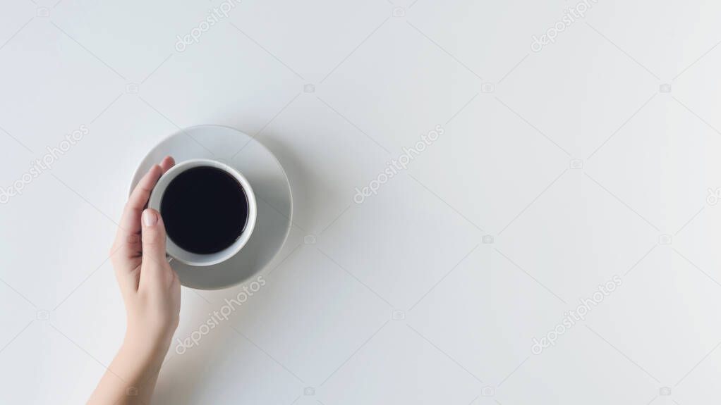 girl hands holding cup with black coffee on the white table. flat lay, top view. coffee art