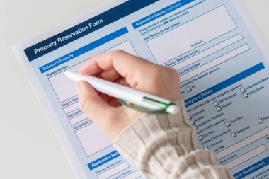 Ofisteki masada emlak rezervasyonu formunu dolduran kadın. Kira sözleşmesi dairesi, ev. Kapatın. Seçici odak