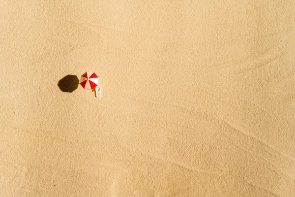 一张日光浴床 休息厅 沙滩上的伞的空中风景 复制空间 夏天和旅行的概念 最低限度主义 — 图库照片