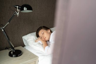 Yatakta Uyuyan Güzel Rahatlama Kadını. Sabahları rahat bir yatakta dinlenen güzel bir kadının portresi. İnsanlar uyur. Perde penceresinden bak.