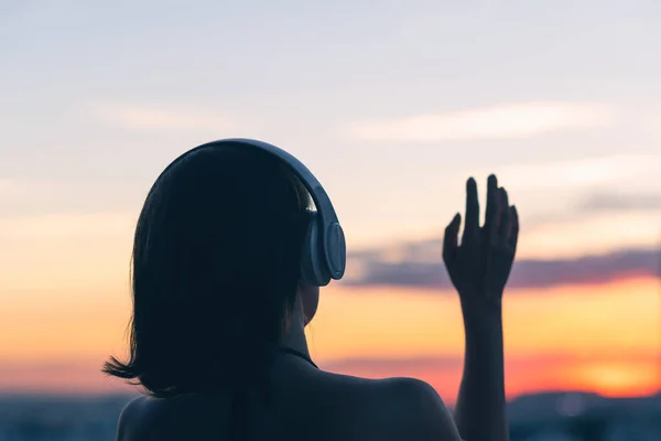 Eenzame Droevige Vrouw Met Een Koptelefoon Tegenover Ondergaande Zon Horizon — Stockfoto