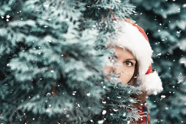 Женщина Прячется Рождественской Ёлкой Девушка Испуганным Открытым Взглядом Шляпе Санта — стоковое фото