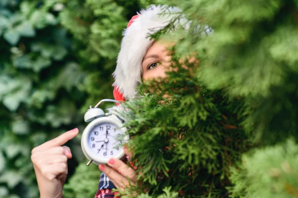 Frauengesicht Mit Weihnachtsmann Roter Mütze Und Wecker Grünen Tannenzweigen Wald — Stockfoto