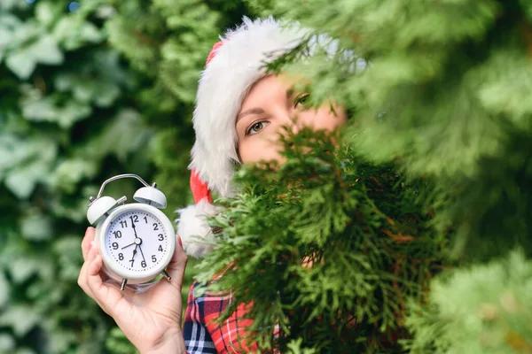 Frauengesicht Mit Weihnachtsmann Roter Mütze Und Wecker Grünen Tannenzweigen Wald — Stockfoto