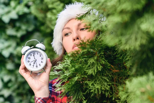 Frauengesicht Mit Weihnachtsmann Roter Mütze Und Wecker Grünen Tannenzweigen Wald — Stockfoto