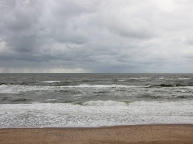 Beyaz Dalgalar ve Bulutlu Hava ile Sahil