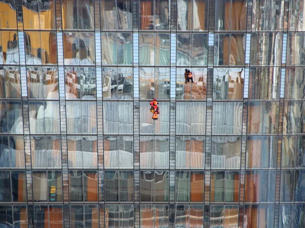 Window Worker on Skyscraper with Colorful Reflection