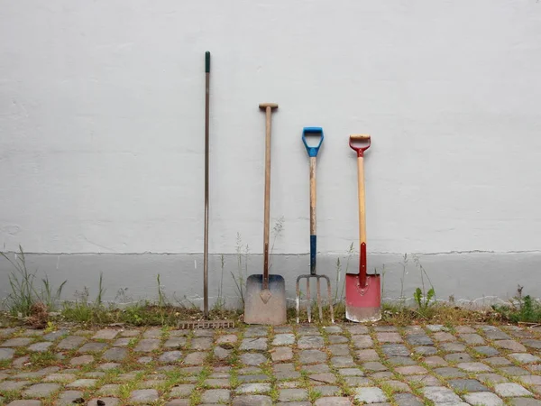 Herramientas de jardín en la superficie de Cobble con pared —  Fotos de Stock