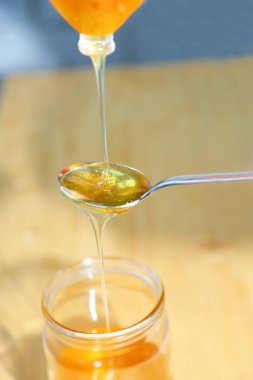 Bir kaşığa bal damlatır ve akar. Arı balı kaşıktan cam kavanoza akar. Yaklaştın. Kavram: Doğal, sağlıklı ve tatlı yiyecekler. Sağlıklı beslenme.