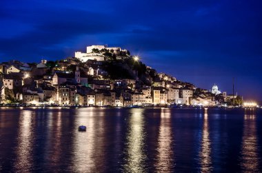 Geceleri Sibenik, Hırvatistan 'ın St. Michael Kalesi manzarası. Hırvatistan 'ın Adriyatik kıyısındaki kentin mavi saat içindeki görüntüsü. Şehir akşamları aydınlanıyor..