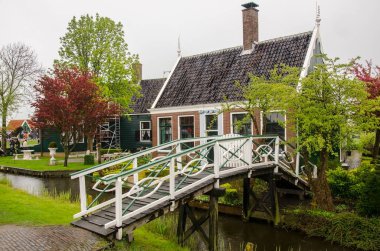 Geleneksel ahşap balıkçı evleri, kanal ve köprü, Kuzey Hollanda, Hollanda. Sokak manzarası ve balıkçı köyündeki geleneksel Hollanda ahşap köprüsü.