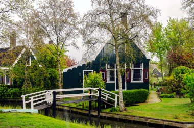 Geleneksel ahşap balıkçı evleri, kanal ve köprü, Kuzey Hollanda, Hollanda. Sokak manzarası ve balıkçı köyündeki geleneksel Hollanda ahşap köprüsü.