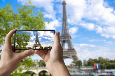 Paris, Fransa 'da Eyfel Kulesi' nin fotoğrafını çeken bir turist. Telefonu tutan ve fotoğraf çeken adam..