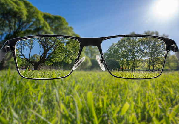 Focused image of landscape. Better vision concept. Through glasses frame. Colorful view of landscape in glasses. 