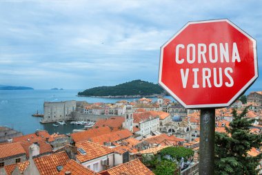 Coronavirus, Hırvatistan 'ın Dubrovnik kentindeki kırmızı çatılar ve şehir duvarlarının üzerinden görüşe karşı imza atıyor. Hırvatistan 'da salgın hakkında uyarı. Coronavirus hastalığı. COVID-2019 uyarı işareti