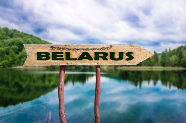 Belarus ahşap ok yolu işareti ormanda göle karşı. Belarus konseptine yolculuk. 