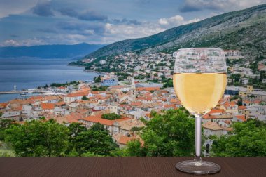 Hırvatistan 'ın Senj kentinde manzaraya karşı bir kadeh beyaz şarap. Manzara Nehaj Kalesi 'nden, kale tepede, Velebit, Hırvatistan.