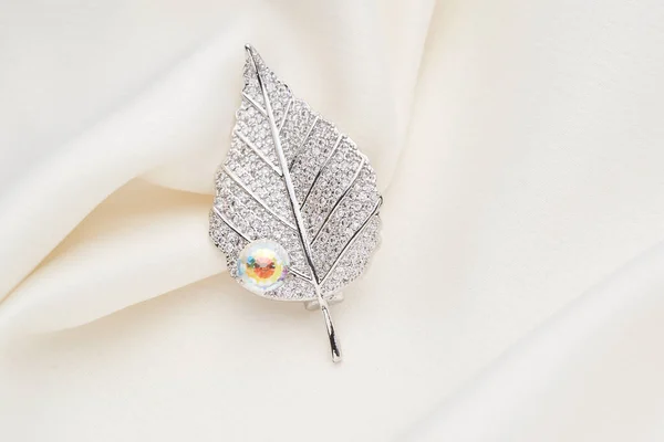 Серебряная брошь в форме листа, с маленькими бриллиантами — стоковое фото