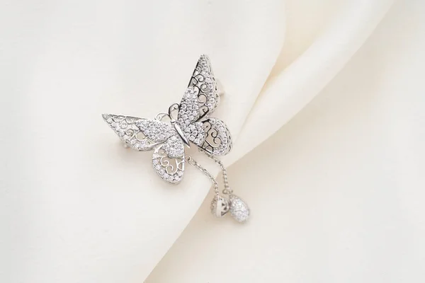 Broche de plata con forma de mariposa, con pequeños diamantes, aislado sobre fondo blanco —  Fotos de Stock