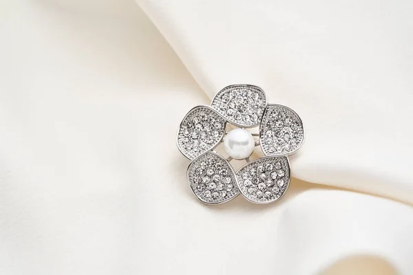 Broche de plata en forma de flor con pequeños diamantes y perlas blancas, aislado sobre fondo blanco . —  Fotos de Stock