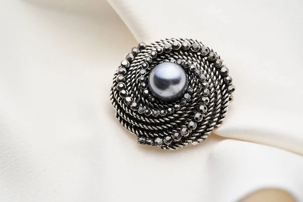 Brosch med små diamanter och svart pärla, isolerad på vit bakgrund. — Stockfoto