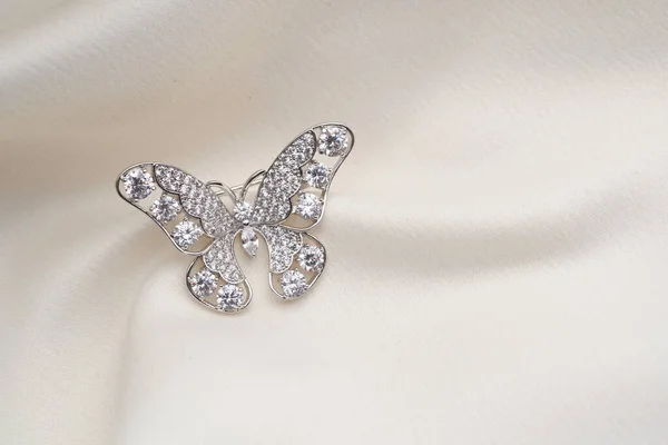 Broche de plata con forma de mariposa, con pequeños diamantes, aislado sobre fondo blanco — Foto de Stock