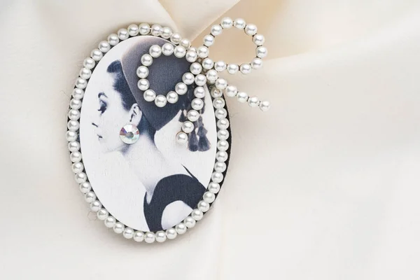 Cameo-Brosche, ein Seitenporträt einer Frau, mit kleinen Perlen an den Rändern auf weißem Hintergrund. — Stockfoto