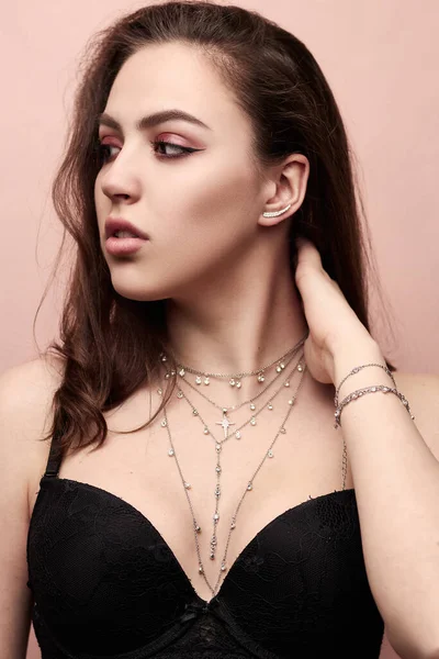 Women's silver pendant around the neck of a girl close up.