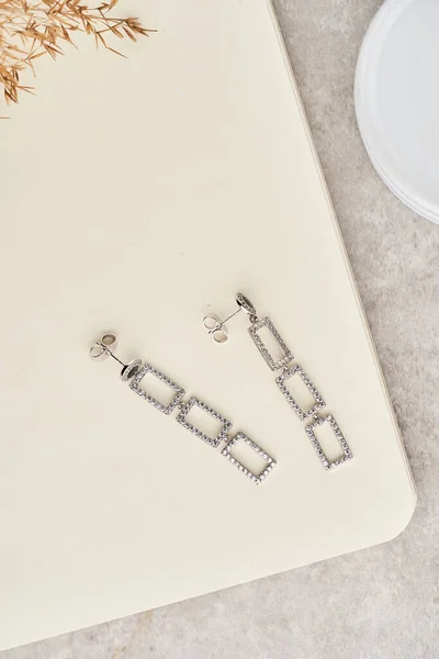 Сучасні геометричні довгі сережки на білому тлі. Сережки у вигляді квадратів. Жіночі аксесуари . — стокове фото