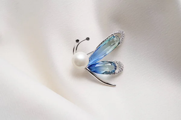 Broche de plata en forma de mariposa, insecto, polilla con diamantes pequeños, aislado sobre fondo blanco —  Fotos de Stock