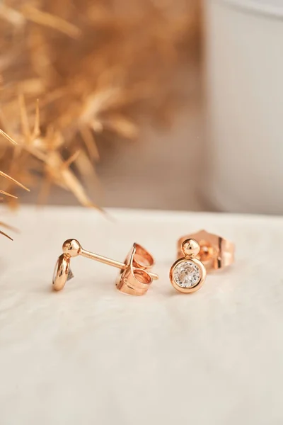 Close up orecchini borchie d'oro, con cristalli bianchi e diamanti. Bellissimi orecchini su sfondo bianco. — Foto Stock