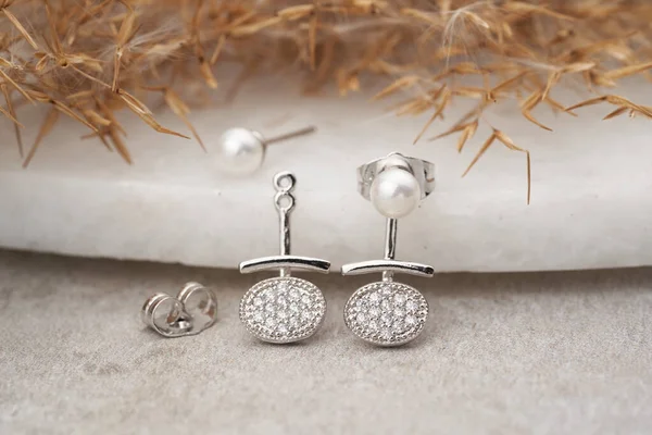 Eleganckie srebrne kolczyki z kryształami i perłami. Luksusowa biżuteria na naturalnym tle. — Zdjęcie stockowe