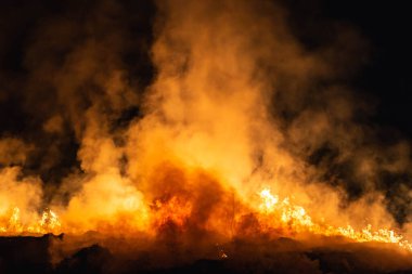 Baharda geceleri bir tarlada yanan otlar.