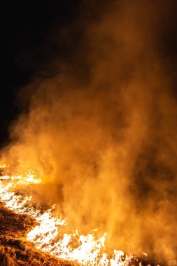 Baharda geceleri bir tarlada yanan otlar.