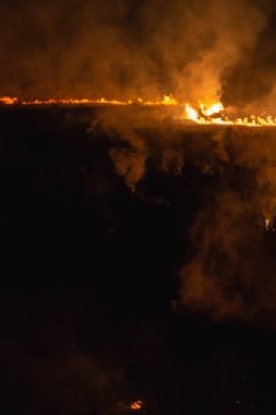Baharda geceleri bir tarlada yanan otlar.