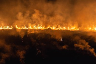 Baharda geceleri bir tarlada yanan otlar.
