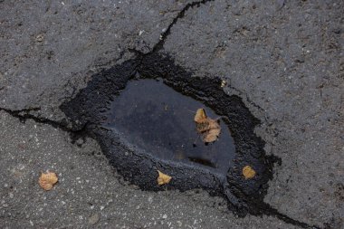 Asfalttaki küçük bir su birikintisinin dokusu