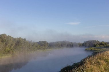 Şafakta nehrin üzerinde sis var.