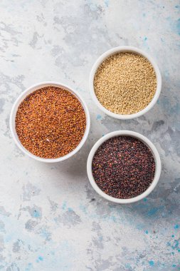Beyaz arka planda siyah, kırmızı ve beyaz kinoa tanecikleri. Glütensiz sağlıklı yemek. Chenopodium kinoası. Yakın plan.