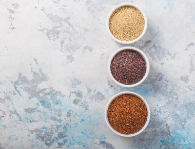 Beyaz arka planda tahta kaşıkta siyah, kırmızı ve beyaz kinoa taneleri. Glütensiz sağlıklı yemek. Chenopodium kinoası. Yakın plan.