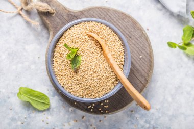 Çiğ siyah kinoa tohumları (lat. Tabakta ahşap kaşıkla Chenopodium kinoası