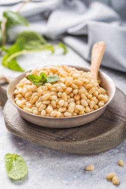 Beton arka planda kabukta çiğ çam fıstığı. Superfood, vegan, vejetaryen gıda konsepti.