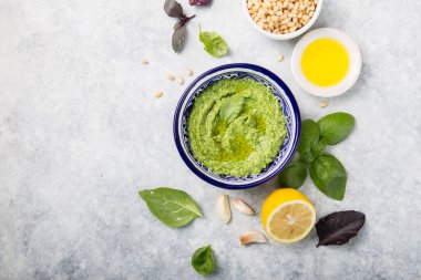 Çam fıstığı, parmesan ve sarımsaklı ev yapımı fesleğen pesto. Tabakta yeşil pesto sosu, üst manzara.