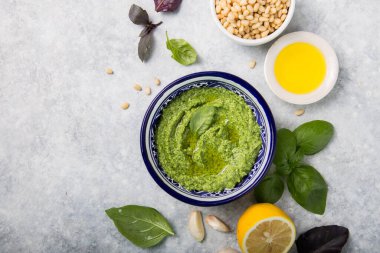 Çam fıstığı, parmesan ve sarımsaklı ev yapımı fesleğen pesto. Tabakta yeşil pesto sosu, üst manzara.