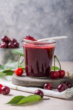 Ev yapımı tatlı ve ekşi vişne reçeli ve ışık masasında taze kirazlar, boşluğu kopyala