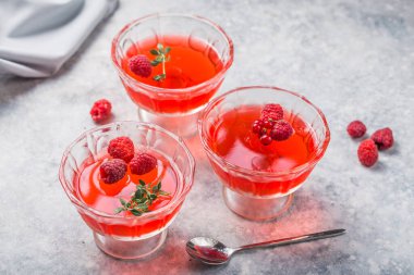 Raspberry jelly garnished with fresh raspberries and thyme on a light background. clipart